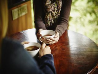 Two women having tea at table in cabin