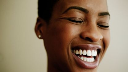 a close-up of a model smiling - under-eye wrinkles