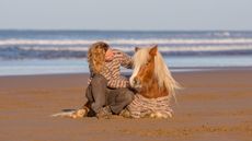 Emma Massingale sitting with a pony on a beach: introduction to liberty training