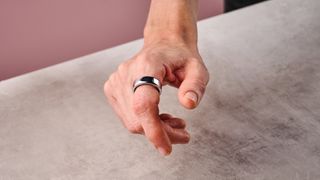 The Oura Ring 3 on a man's index finger showing the top side.