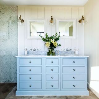 Blue chest of drawers and double sink in bathroom