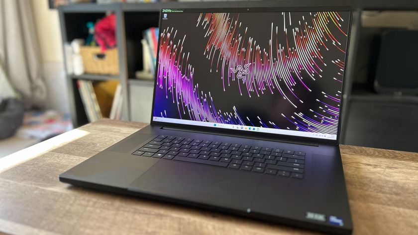 Razer Blade 18 gaming laptop open showing screen on a wooden table