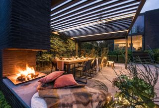 cosy patio scene with outdoor fire place from garden house design