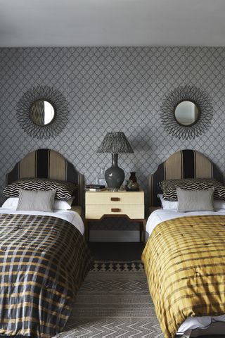 Twin single beds in bedroom black and gray headboard, gold and black check duvets