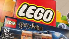 A LEGO Harry Potter set in the box sits on a shelf in front of the LEGO logo