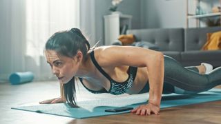 Woman performing a push up in her sitting room at home