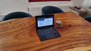 black laptop sitting on wooden desk