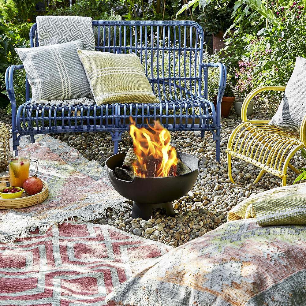 garden area with cushions on bench and fire pit in garden