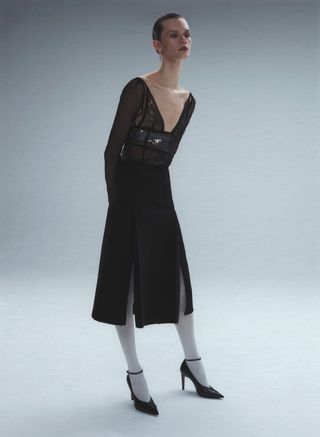 Model leans over in black Victoria Beckham knee-length dress