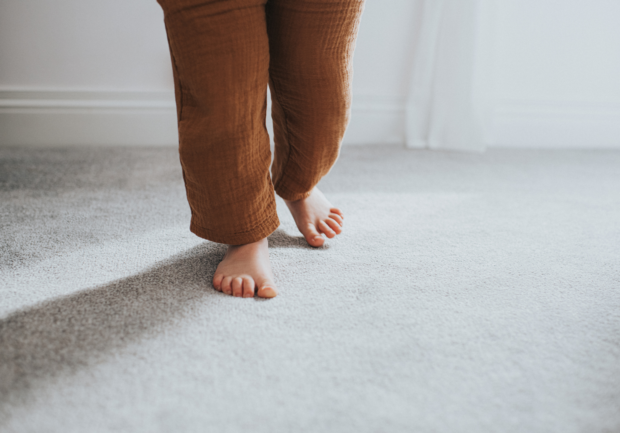 child walking on clean grey carpet