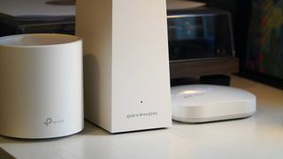 Gryphon AX, TP-Link Deco X60, and Eero Pro on a table