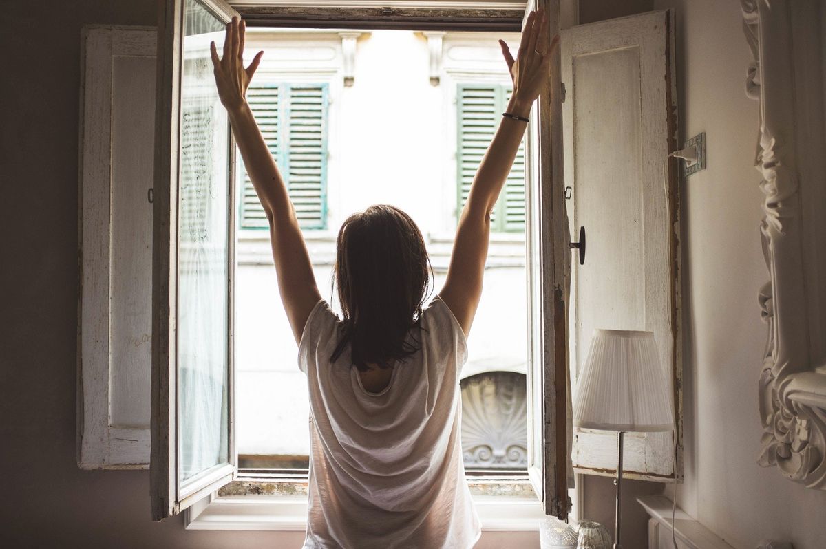 Woman stretching in front of window