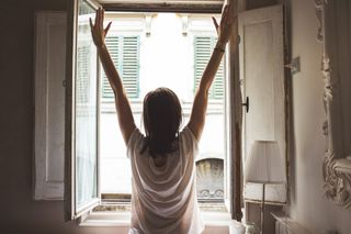 Woman stretching in front of window