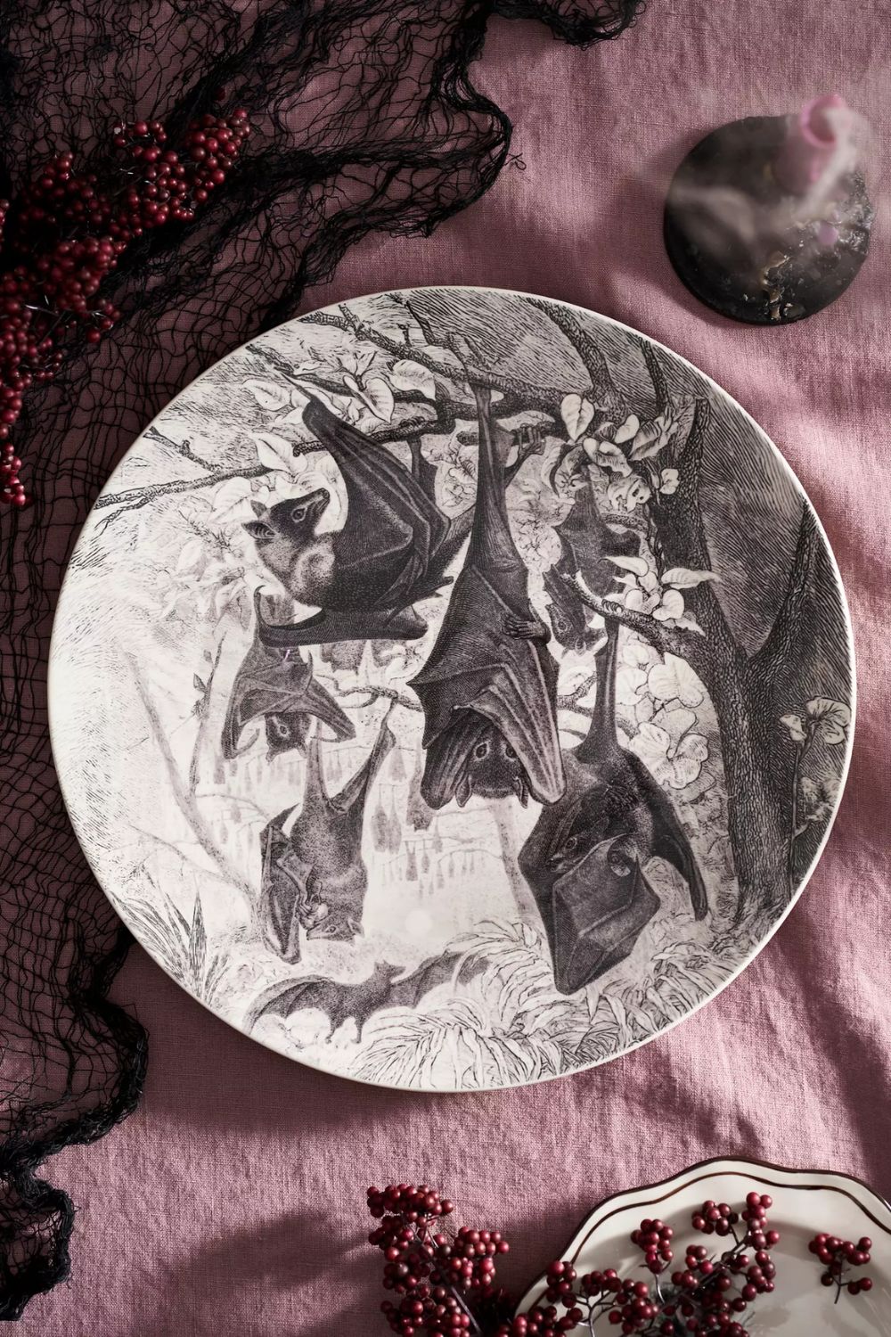 Round serving plate with hanging bat illustration