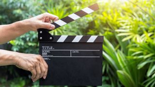 A man holding movie clapper