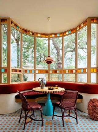 Dining nook with built-in banquette seating and window with stained glass detailing