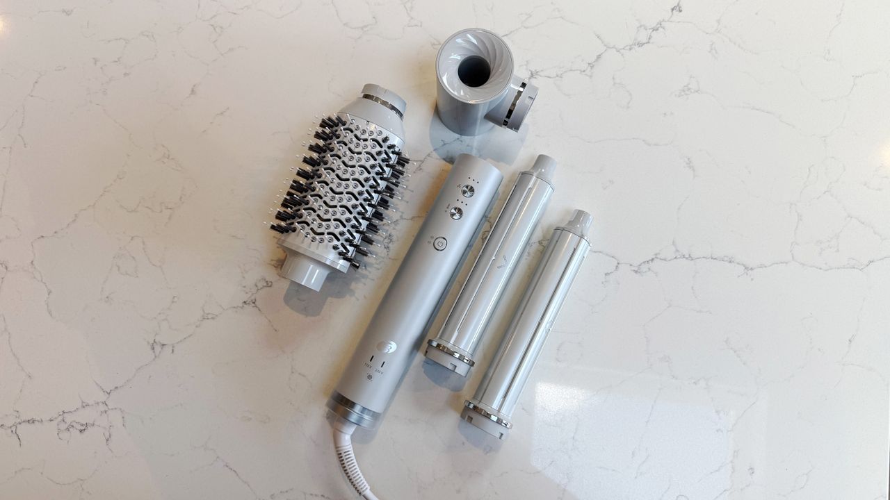 Top-down view of the T3 Aire 360 and attachments: oval brush top left, SoftAire concentrator top right, two ceramic curling barrels to the right, base in the centre