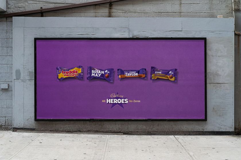 A large outdoor billboard advertisement with a purple background showing four miniature Cadbury&#039;s chocolate bars named after the band members of Queen: Freddie Mercury, Brian May, Roger Taylor, and John Deacon, with the slogan &quot;Cadbury All HEROES No Zeros.&quot;