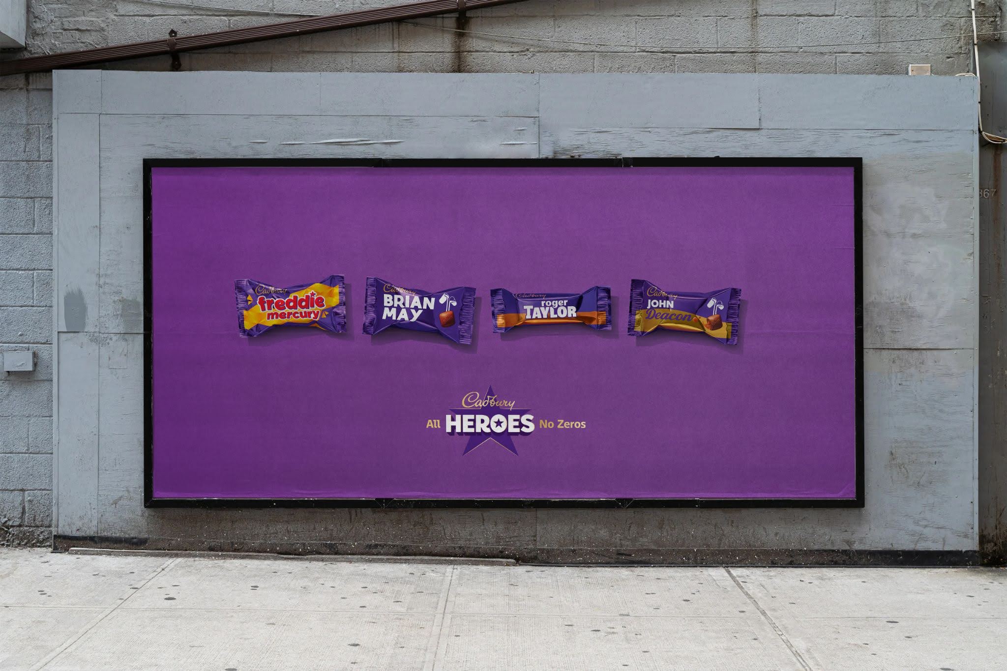 A large outdoor billboard advertisement with a purple background showing four miniature Cadbury's chocolate bars named after the band members of Queen: Freddie Mercury, Brian May, Roger Taylor, and John Deacon, with the slogan "Cadbury All HEROES No Zeros."