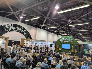 Reporters gather at the Martin booth at the 2025 NAMM show in Anaheim, California