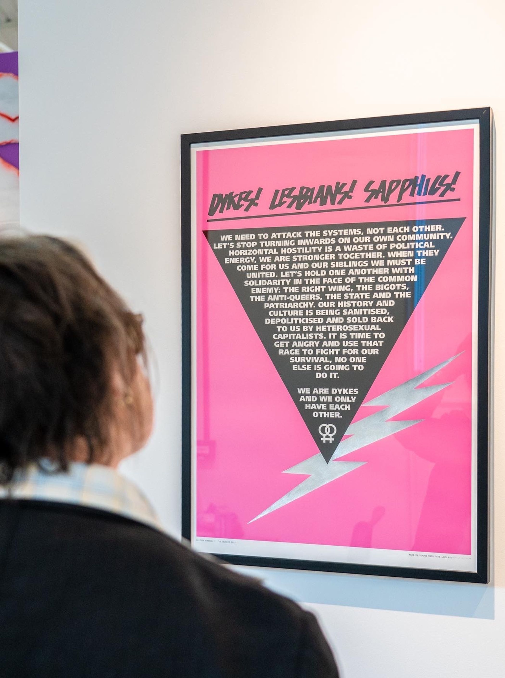 a graphic slogan poster with a pink background and black triangle