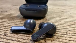 JBL Live Pro 2 earbuds on wooden table