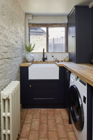 small laundry room ideas with dark cabinets and terracotta floor tiles by Ca'Pietra