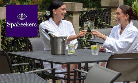 Spa Seekers logo top left with a picture of two women posing in dressing gowns and champagne