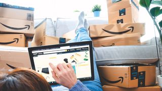 Pila de paquetes Amazon Prime. mujer comprando online en el Amazon Prime Day.