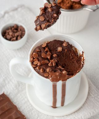 Chocolate mug cake with chocolate chips prepared in a white ceramic mug