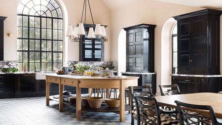 cream kitchen with black cabinets by Barlow & Barlow and a curved wooden butcher block island