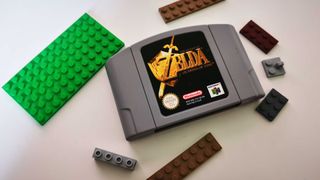 A Legend of Zelda: Ocarina of Time N64 cartridge beside some Lego pieces on a white surface