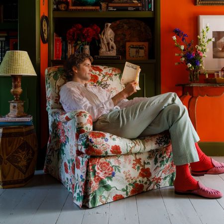 An image of Who What Wear UK Editor in Residence, Max Hurd, sitting in the armchair he designed in collaboration with The Room Upstairs.