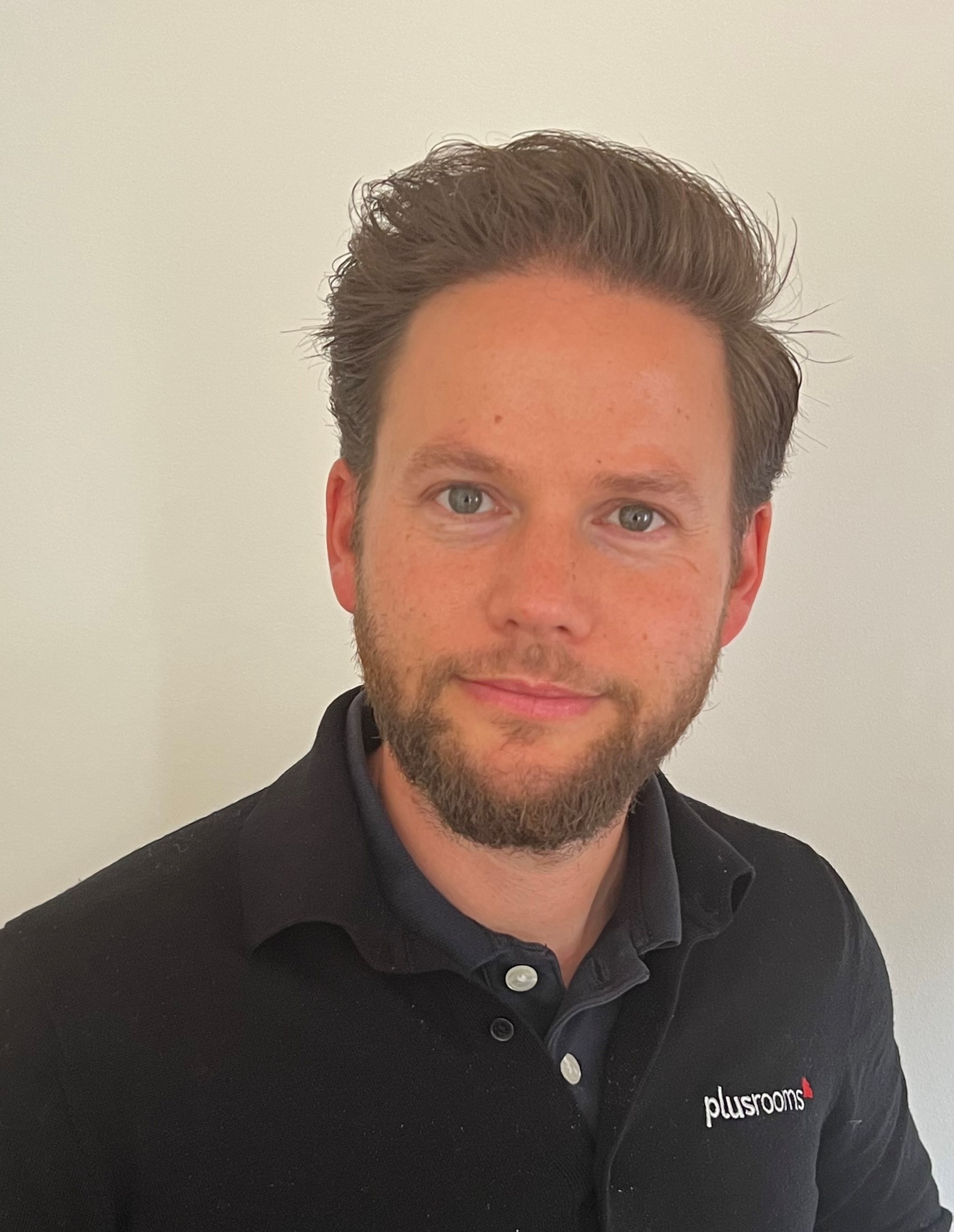 A picture of a man with a beard and a black top
