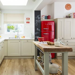 kitchen with painted cabinets, island and red fridge