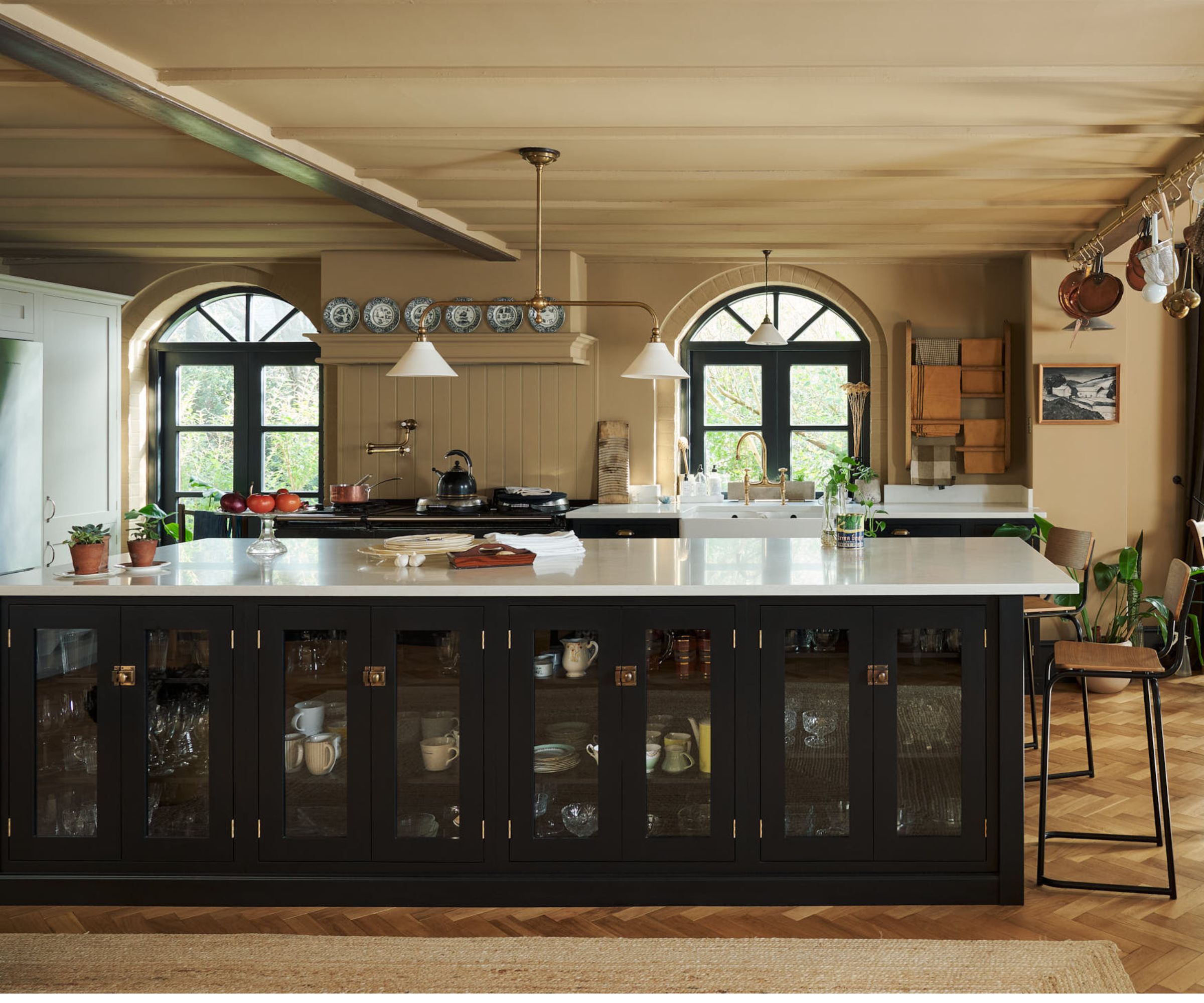 A historic house kitchen with paneled walls and a large kitchen island with glazed doors