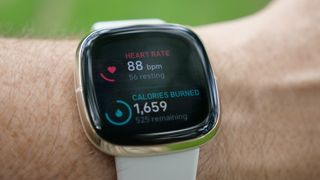 Fitbit Sense smartwatch on wrist with heart monitoring on display