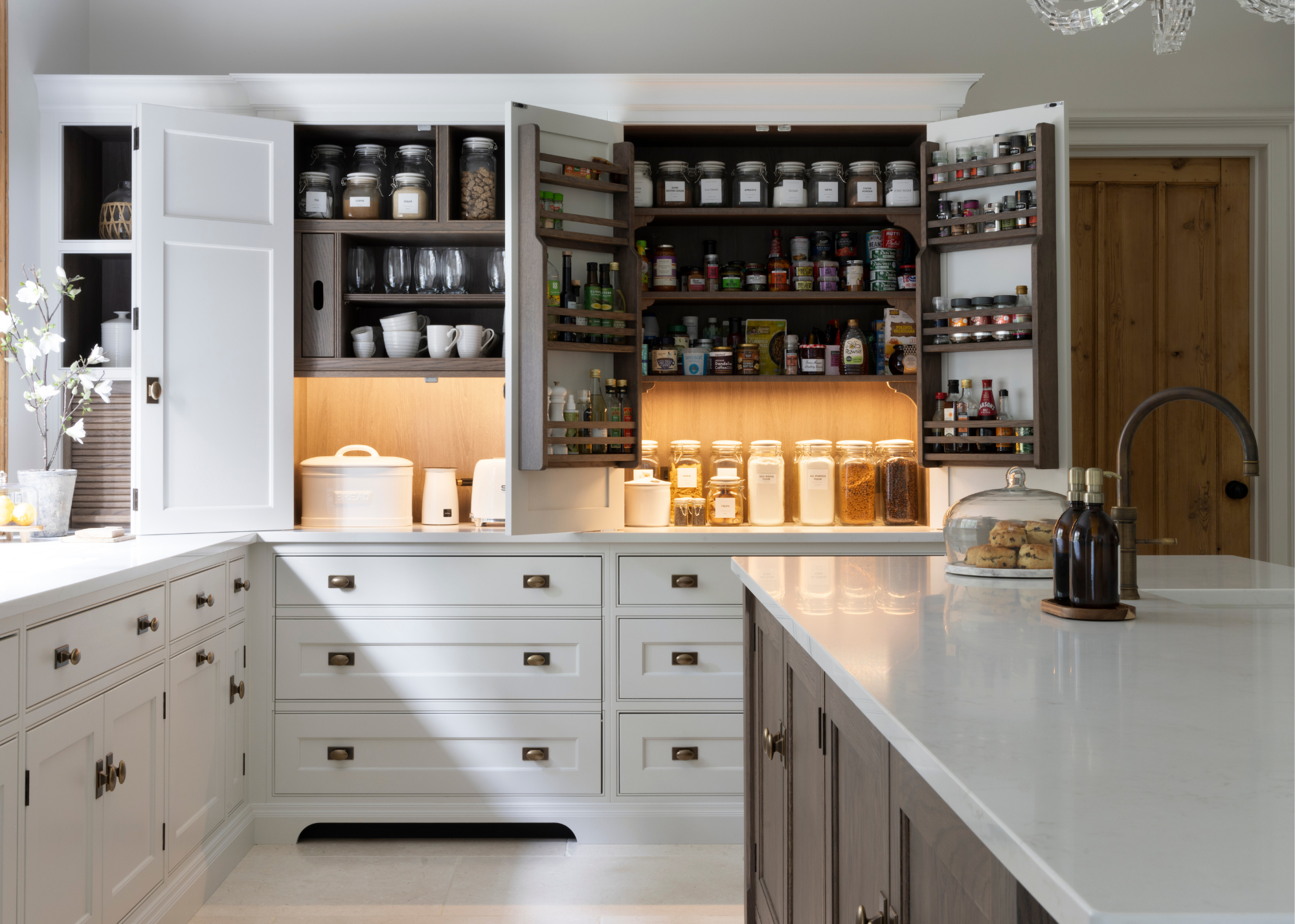 A white kitchen with lots of hidden storage in the breakfast cupboards and sublt but effective lighting inside