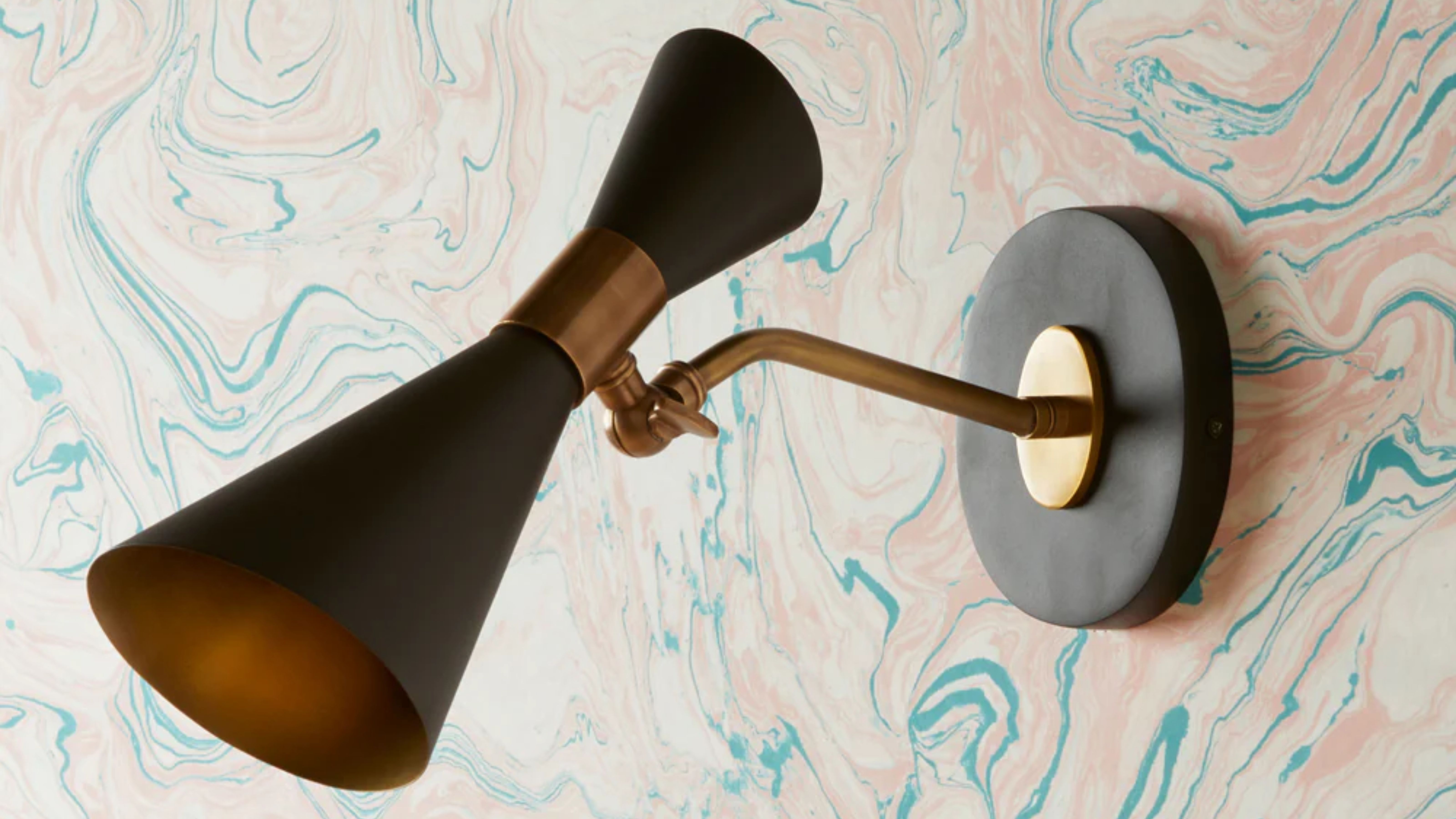 Pooky Bow Tie Sconce mounted onto an a wall with abstract pastel patterned wallpaper