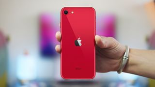 Un iPhone SE rojo en la mano de alguien