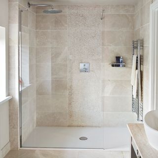 beige bathroom with shower and towel rack