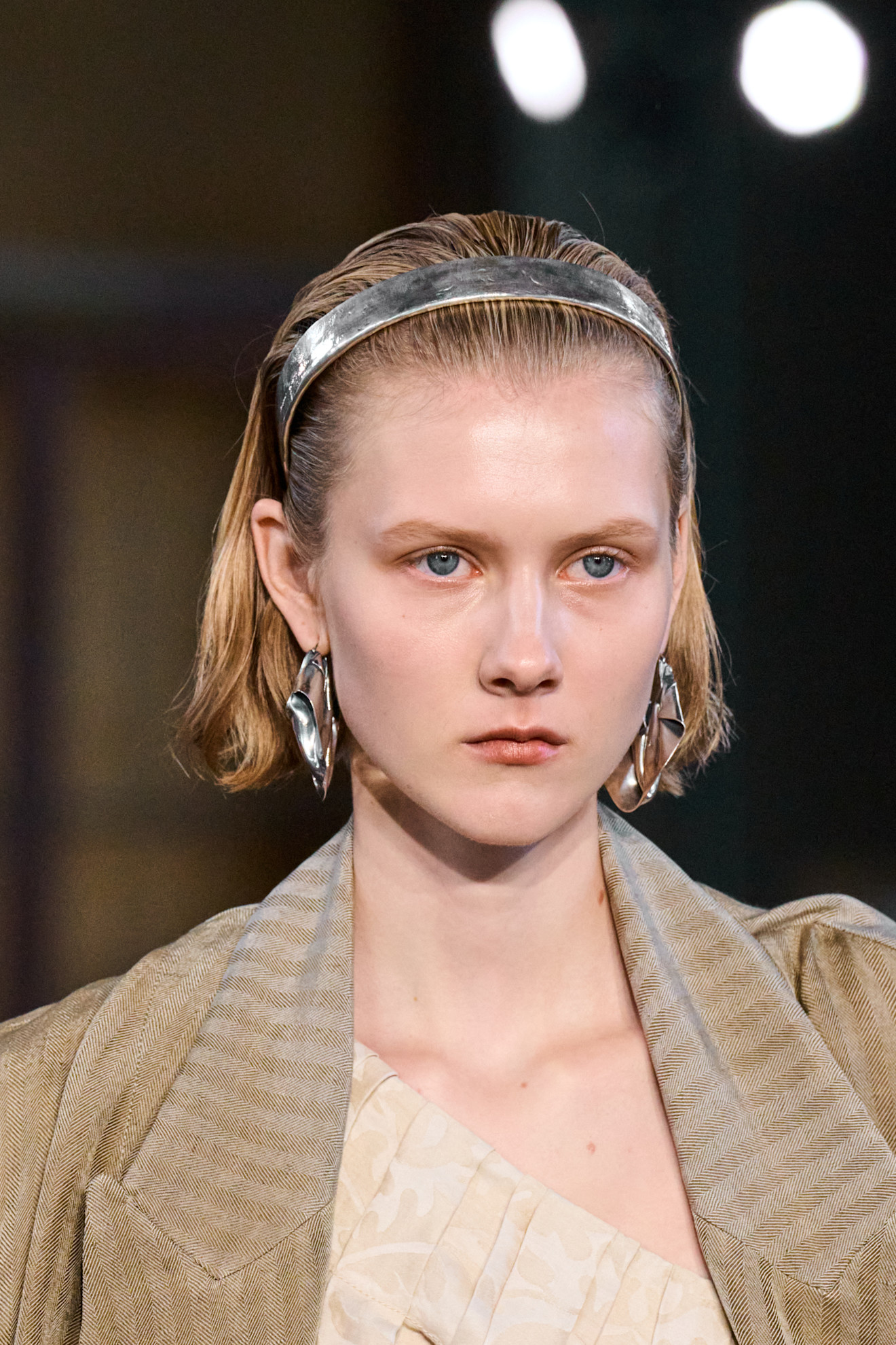 model with short blonde hair wearing a silver headband