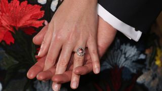 Princess Eugenie wears a ring containing a padparadscha sapphire surrounded by diamonds as she poses with Jack Brooksbank in the Picture Gallery at Buckingham Palace after they announced their engagement. Princess Eugenie wears a dress by Erdem, shoes by Jimmy Choo and a ring containing a padparadscha sapphire surrounded by diamonds on January 22, 2018 in London, England.. They are to marry at St George's Chapel in Windsor Castle in the autumn this year.
