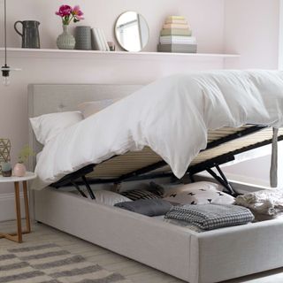 small bedroom with ottoman bed lifted up