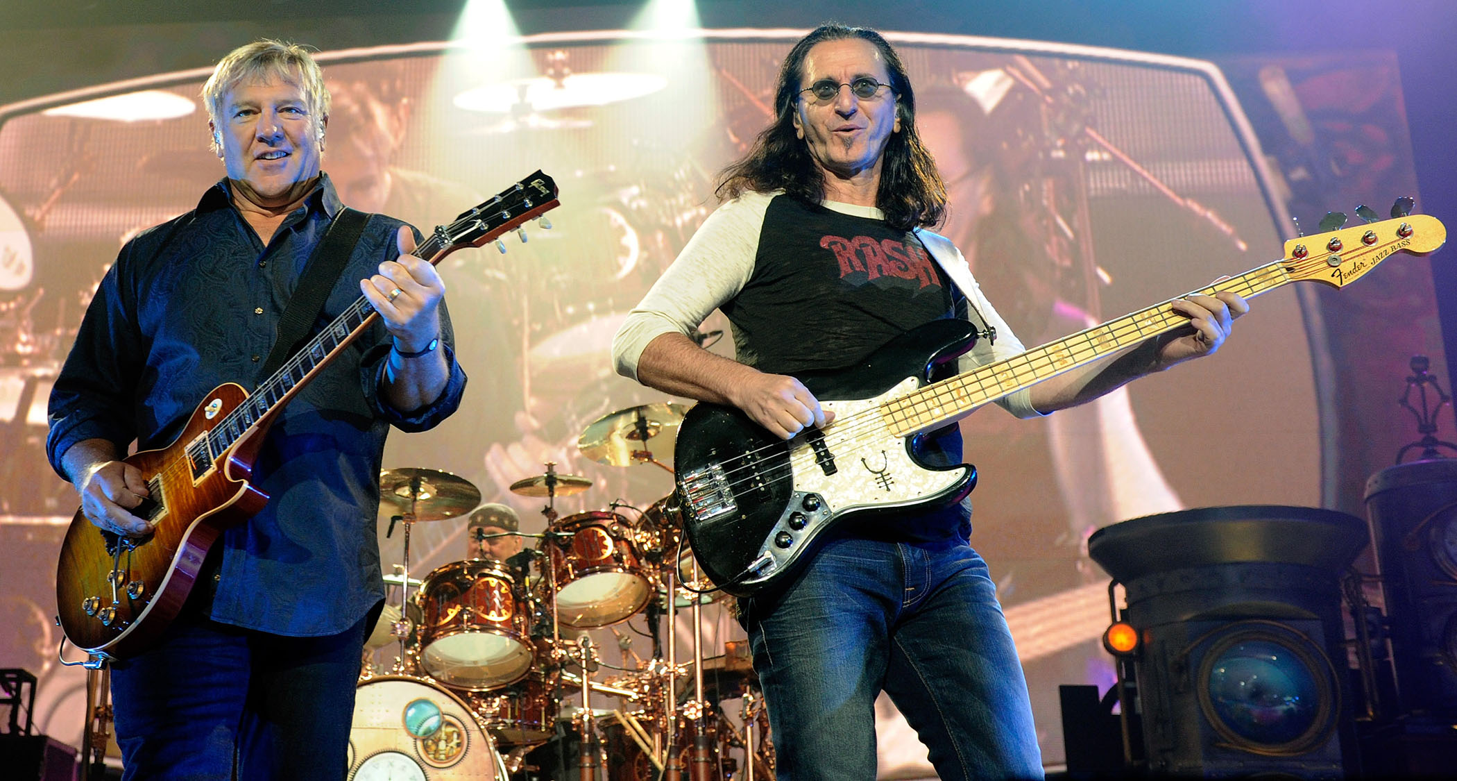 Rush perform at the MGM Grand Garden Arena, Las Vegas, in 2010, with Alex Lifeson [left] playing a Les Paul, Geddy Lee playing a Fender Jazz Bass, with the late Neil Peart in the background on drums.