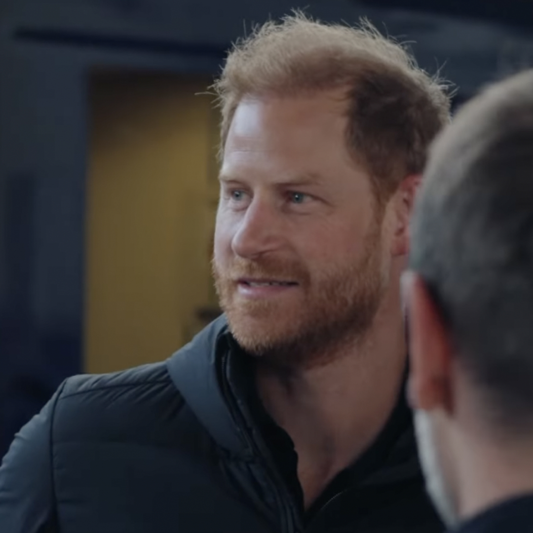 Prince Harry smiling wearing a black jacket