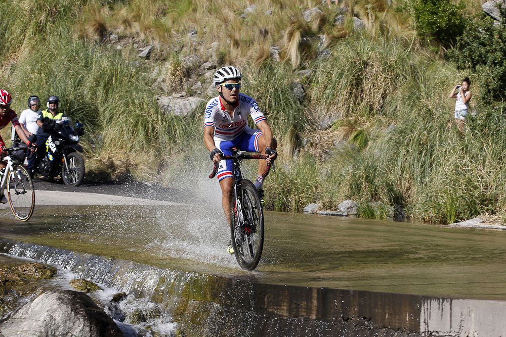 A rider slides through a wet patch during stage 6.