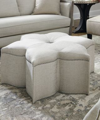 A flower-shaped grey upholstered ottoman coffee table