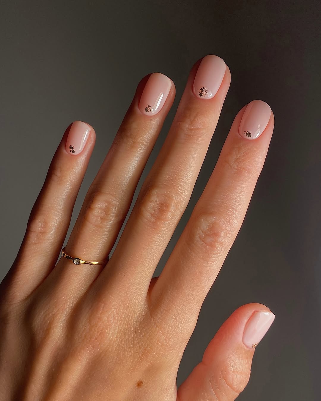 A manicure featuring a dusting of chrome glitter at the top of each nail by Mate Janova