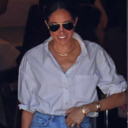 Meghan Markle wearing a white button down shirt by Anine Bing with jeans and her Princess Diana Lady Dior bag in California